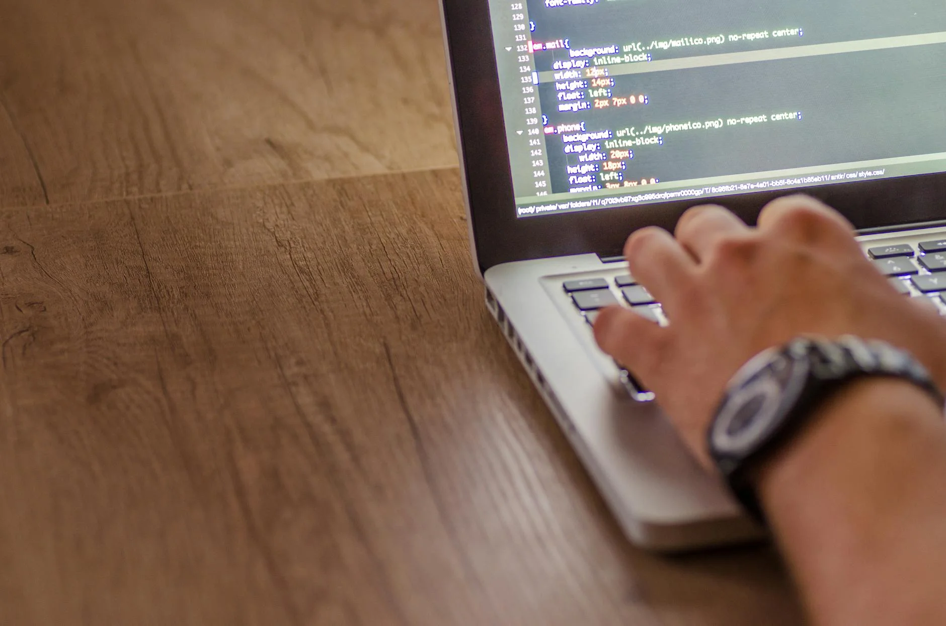 Developer reviewing code on a laptop with multiple browser tabs open
