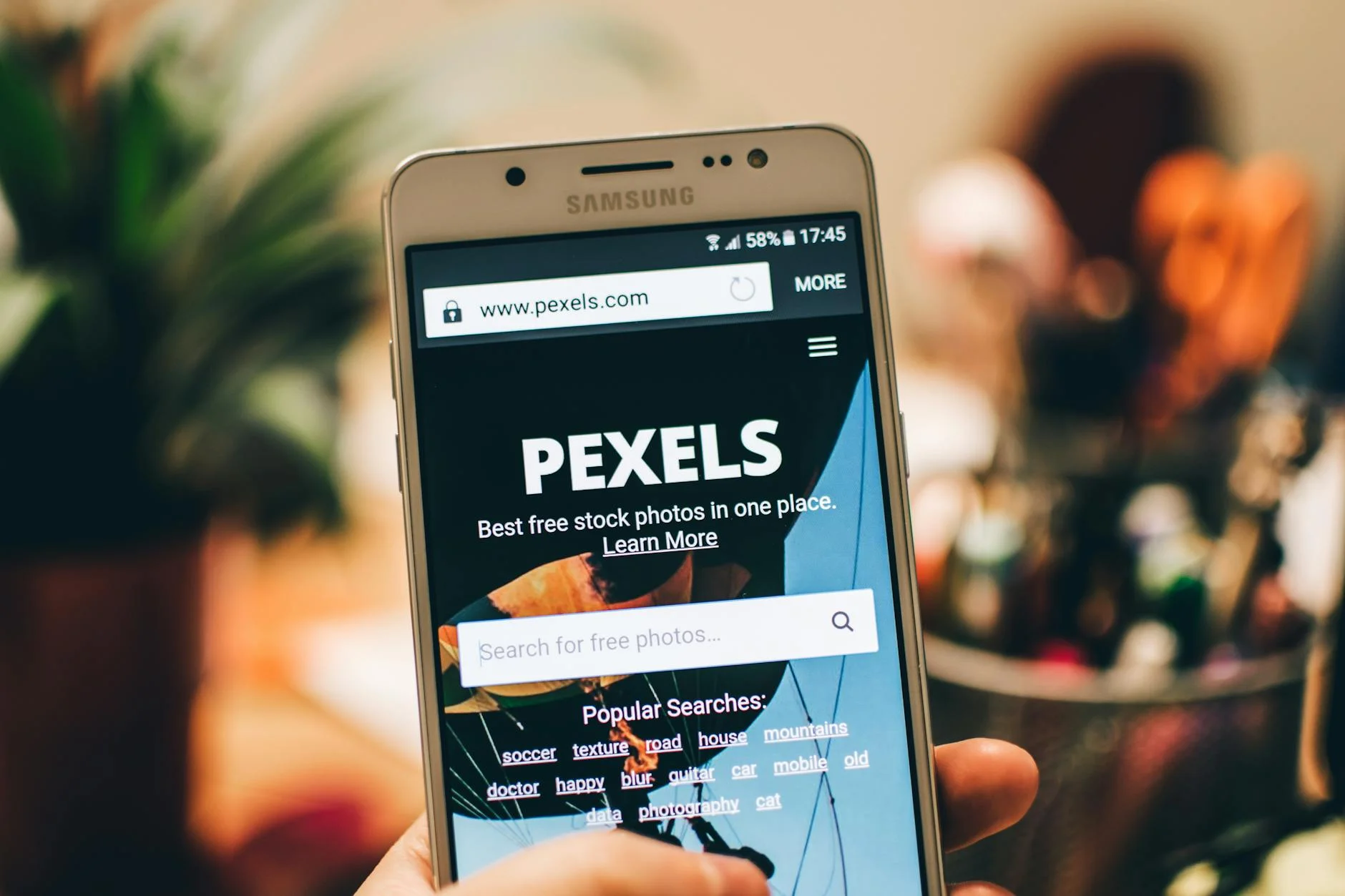Web designer reviewing mobile layouts on smartphone and laptop screen