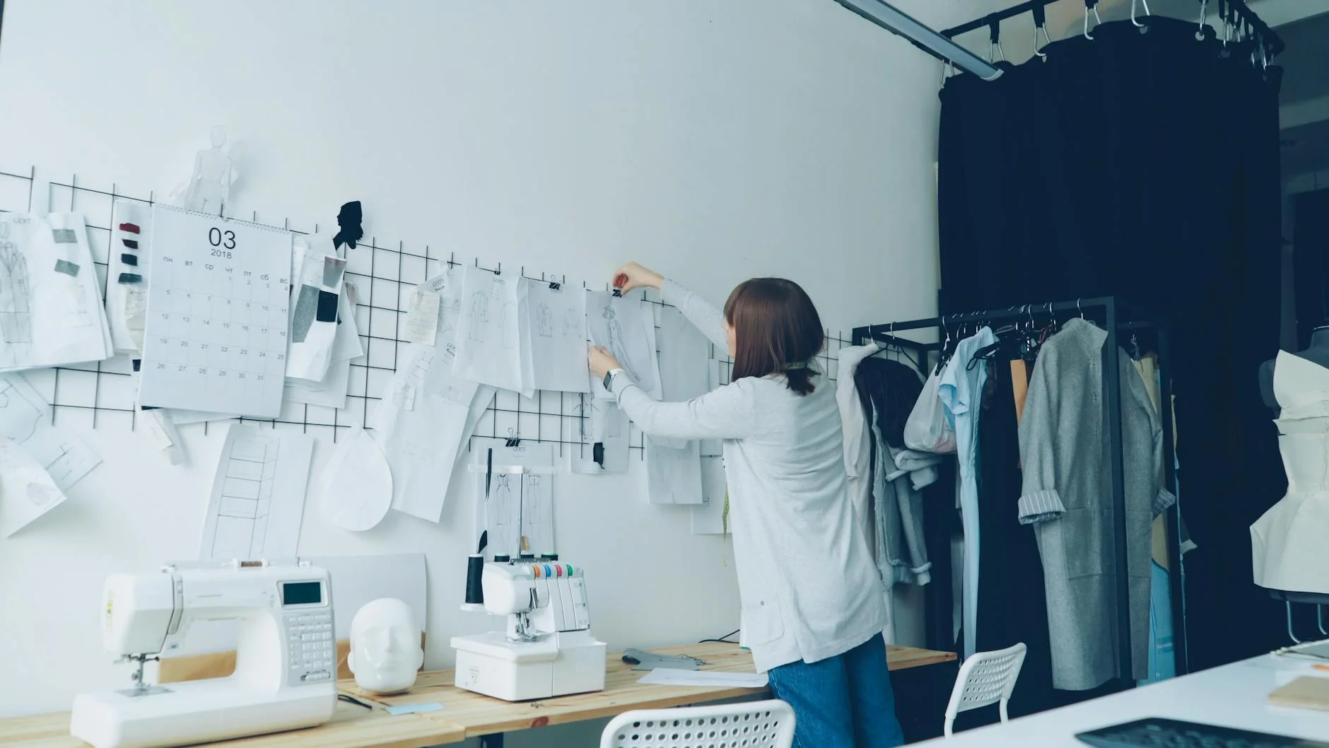 Design sketches and wireframe layouts pinned to a studio wall