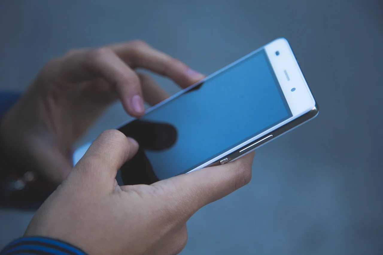 A person holding a smartphone close up showing a mobile app interface