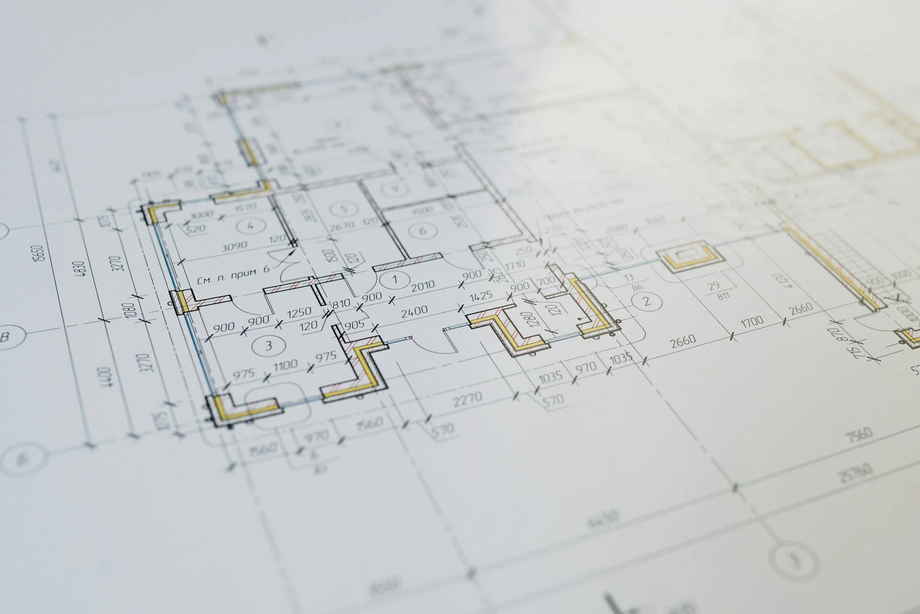 Open blueprint plans with pencil and ruler laid out on a drafting table