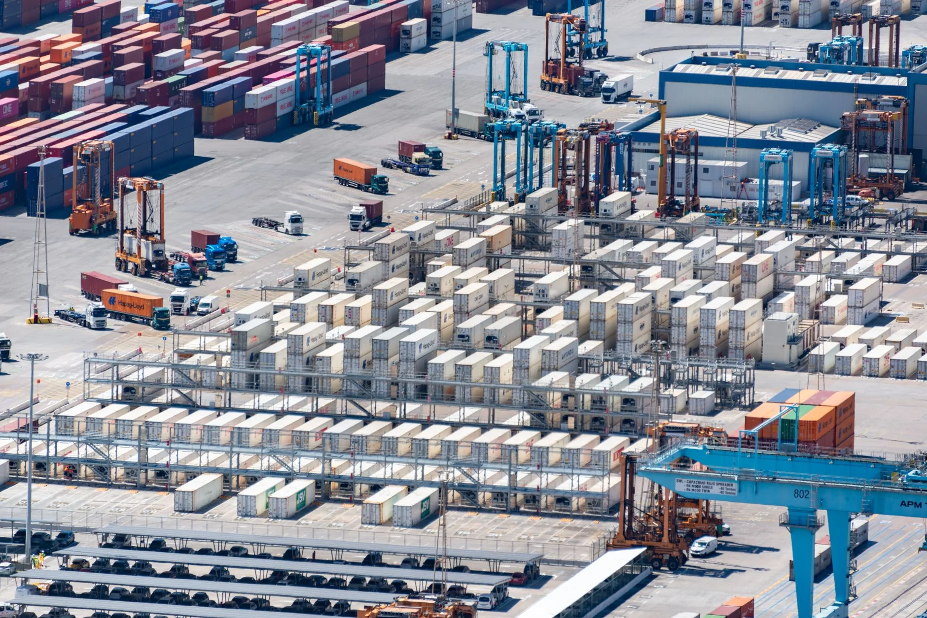 An aerial view of a shipping container yard showing rows of stacked containers