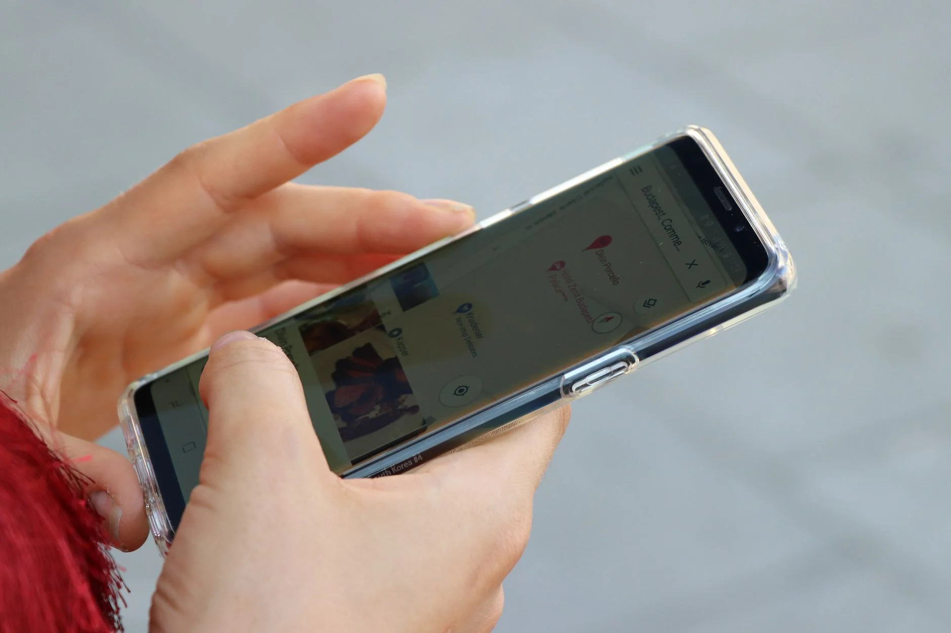 Close-up of a hand holding a smartphone displaying an app interface