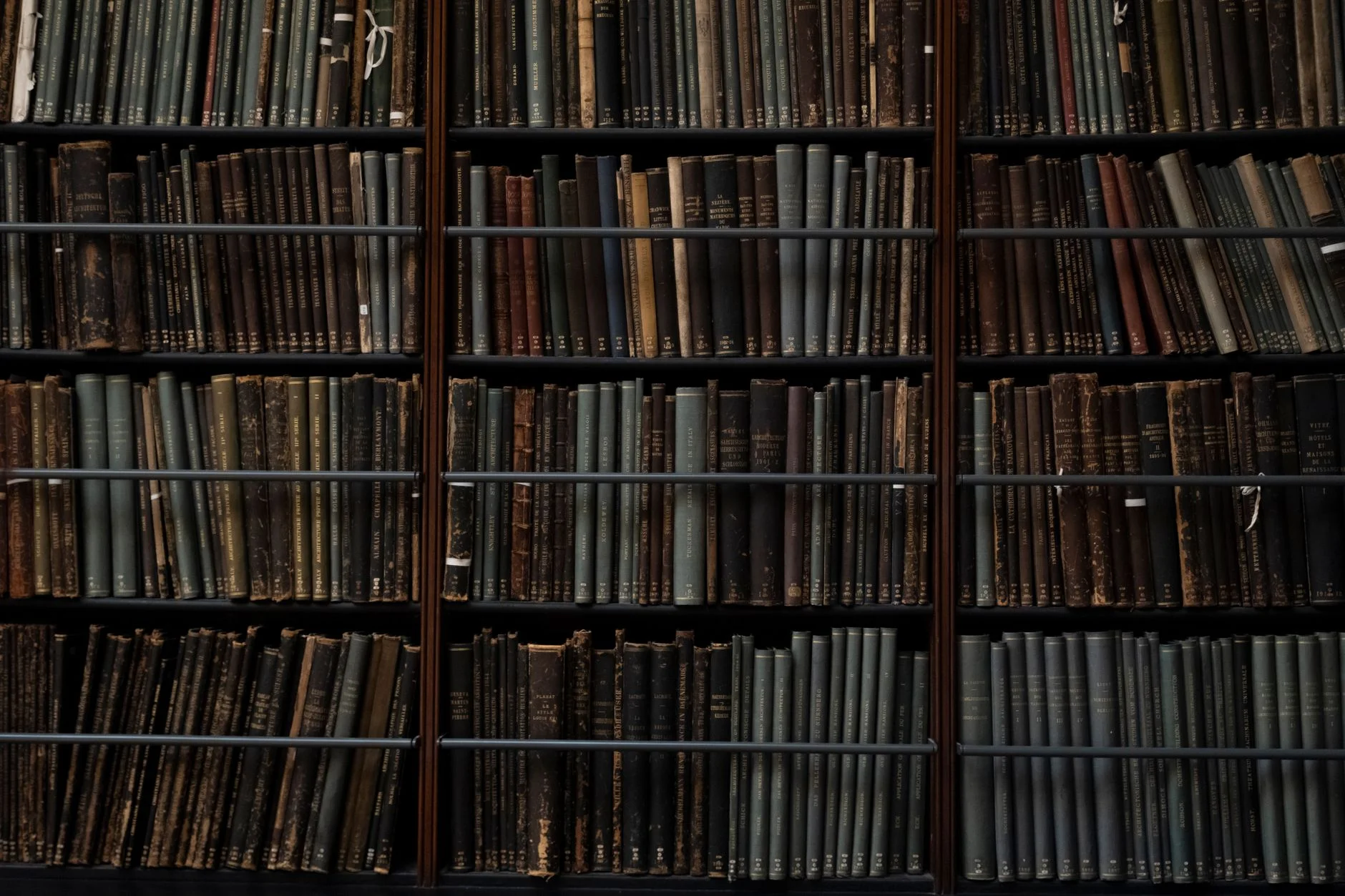 A view down rows of archive shelving in a library, filled with bound records