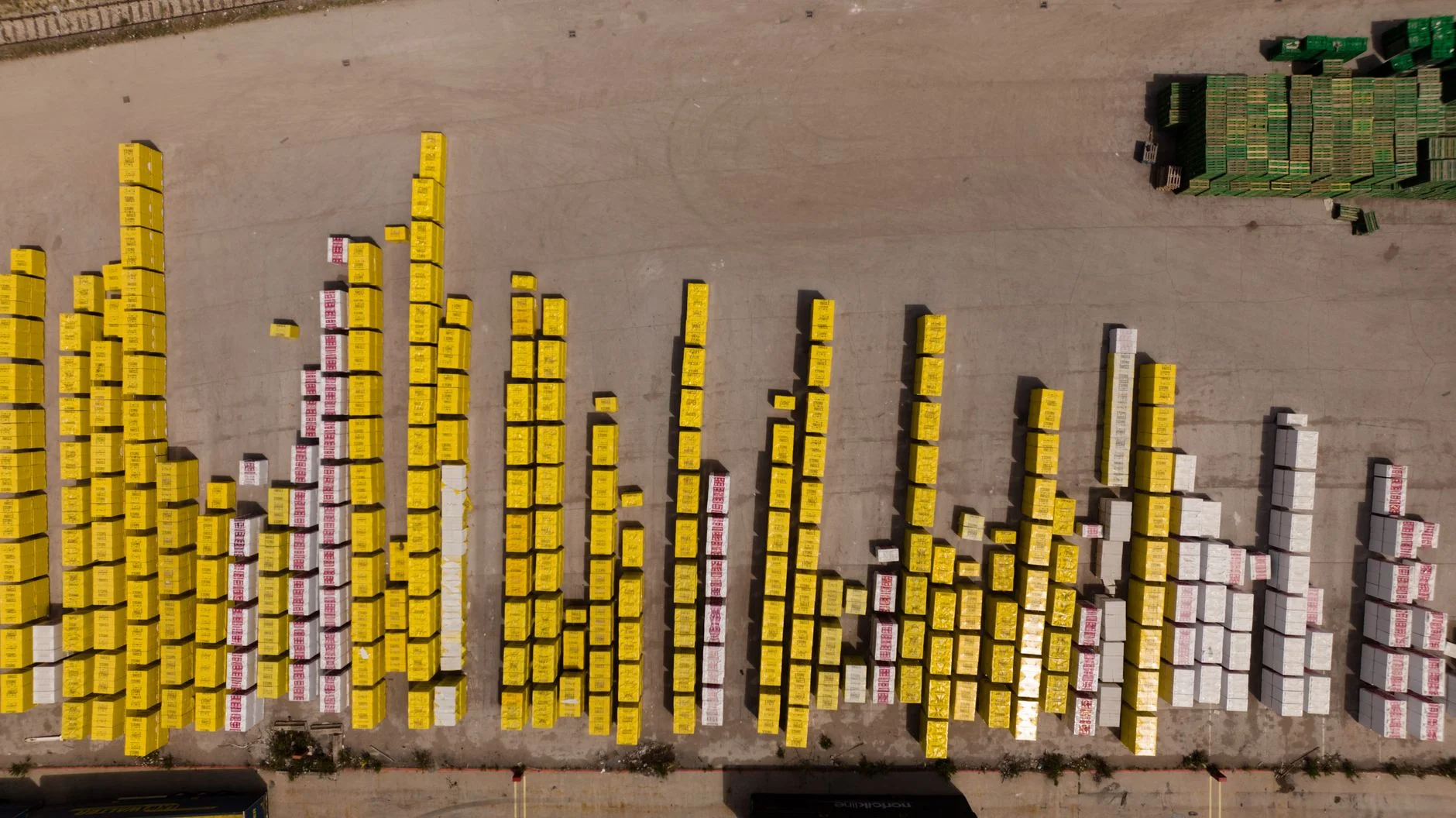 An aerial view of a busy shipping container yard with neatly stacked rows