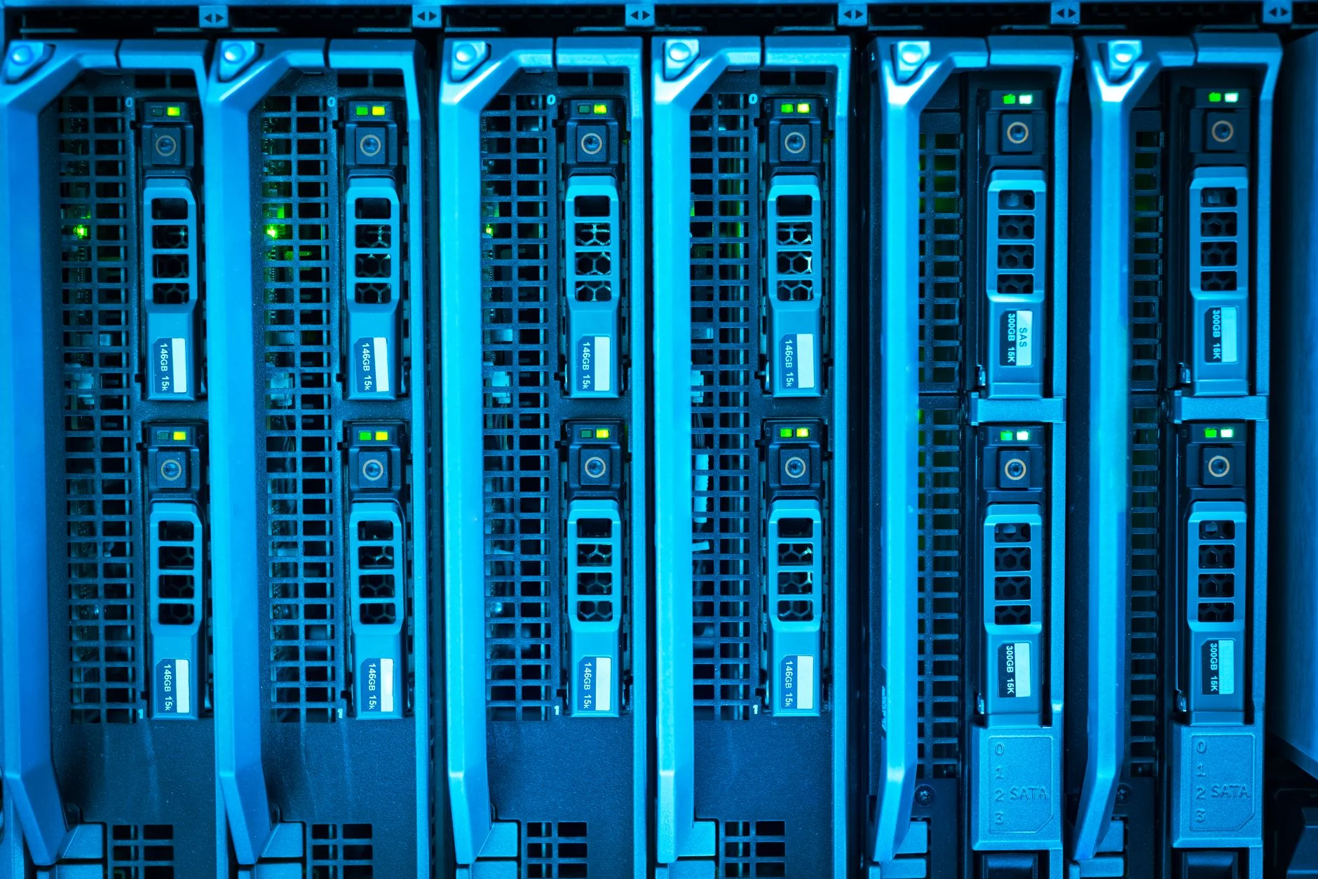 rows of humming data center equipment with cooling infrastructure running between racks