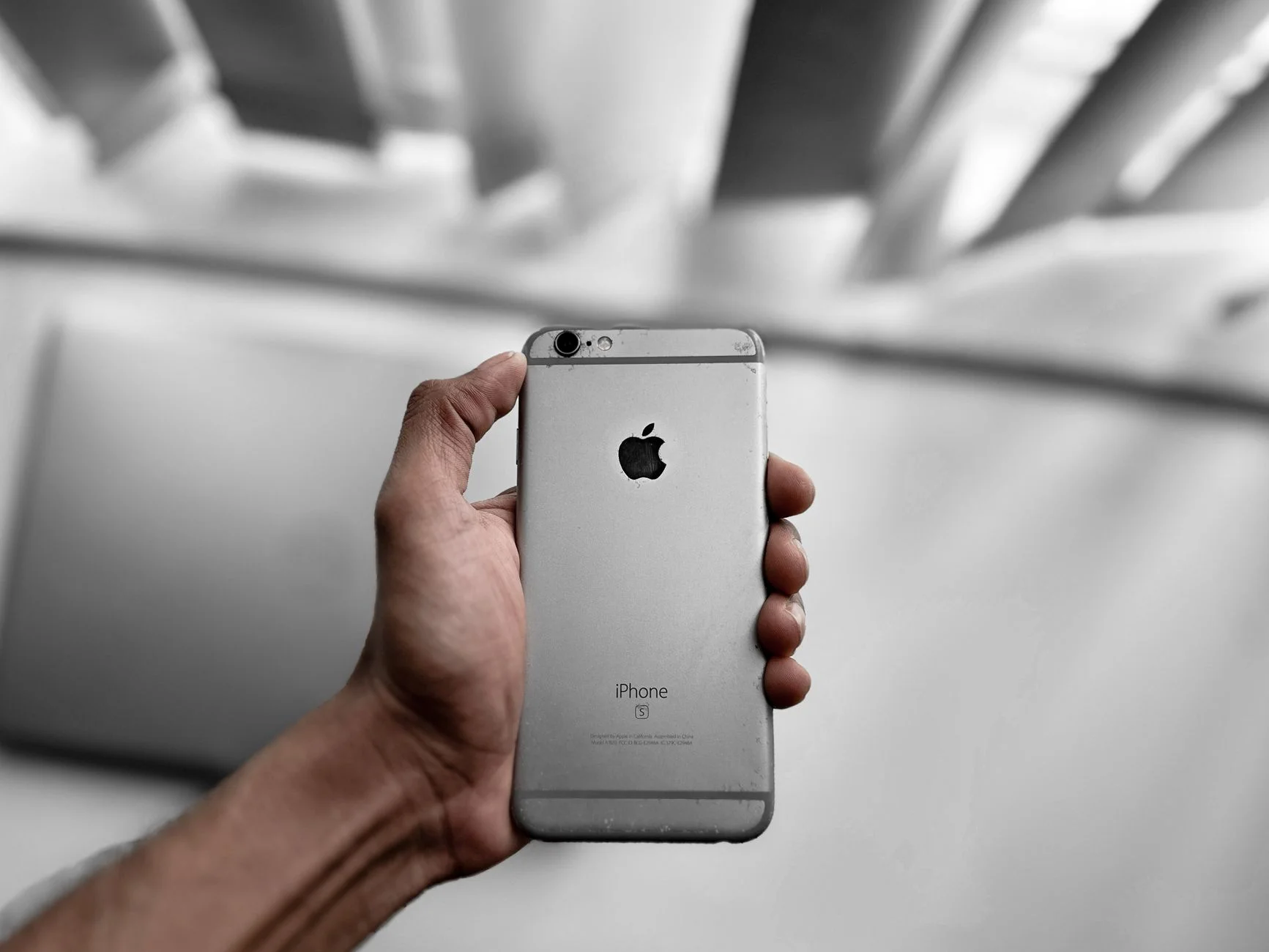A hand holding a smartphone with a notification visible on the lock screen