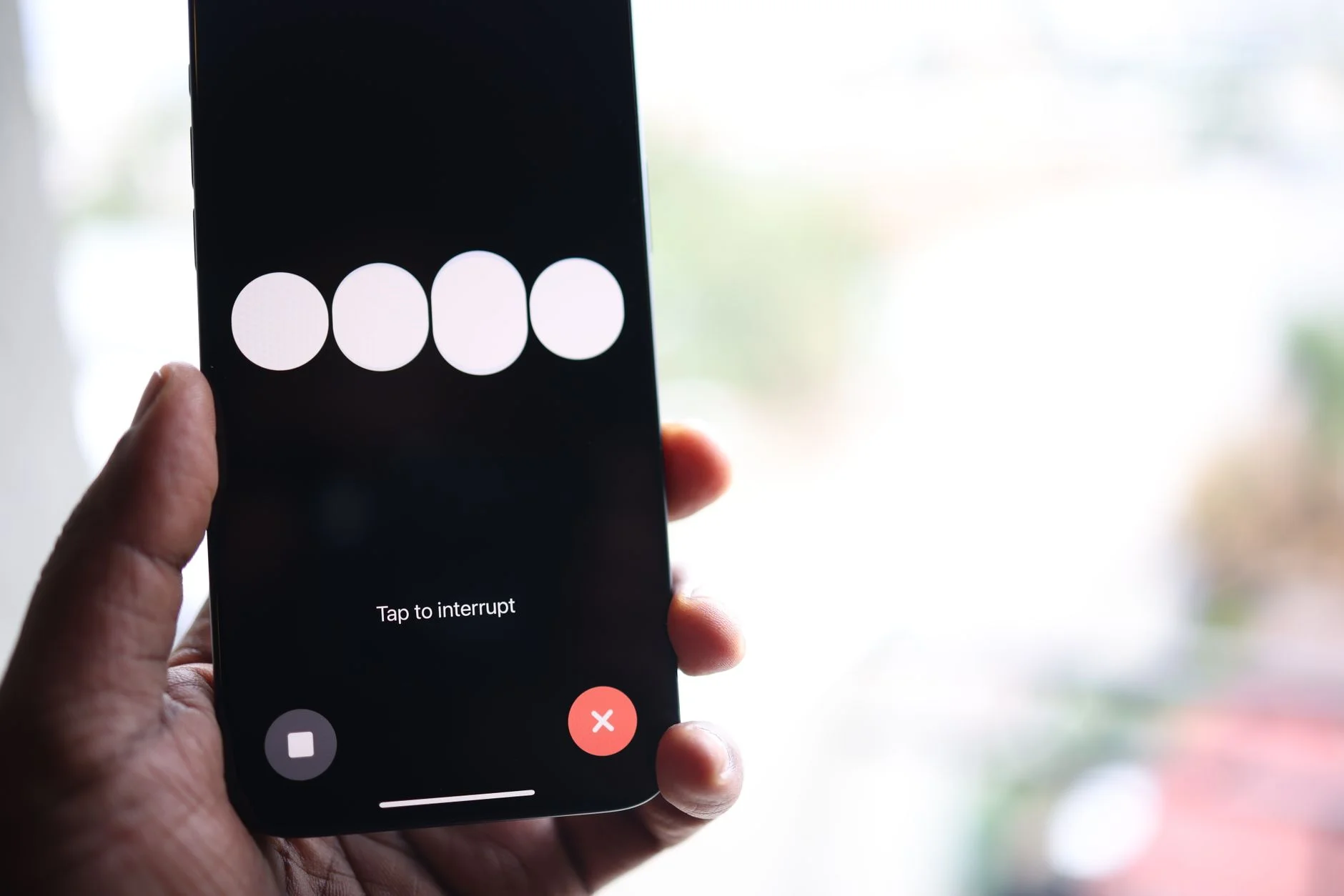 A hand holding a smartphone displaying an app interface