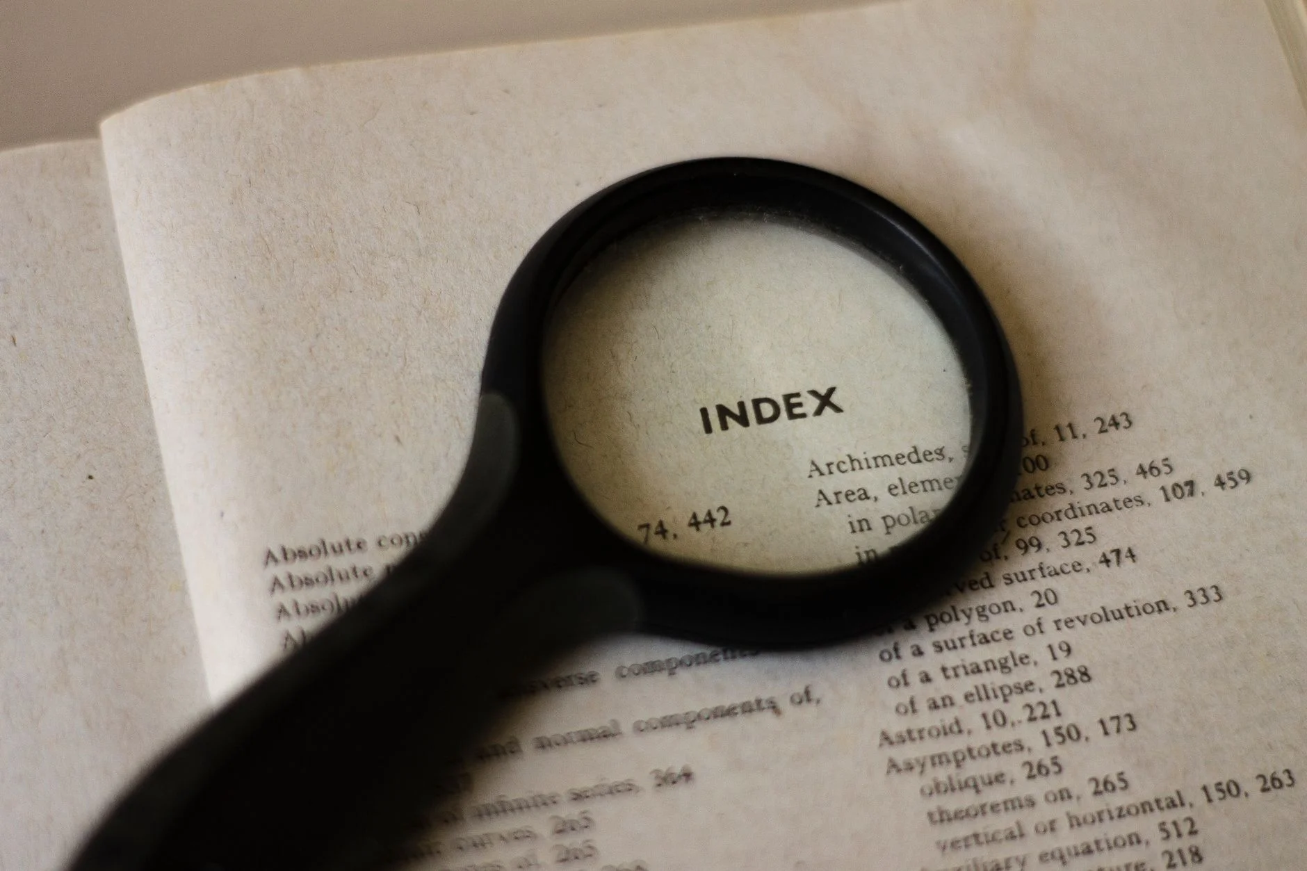 A magnifying glass held over a printed document on a desk, representing an SEO rendering audit