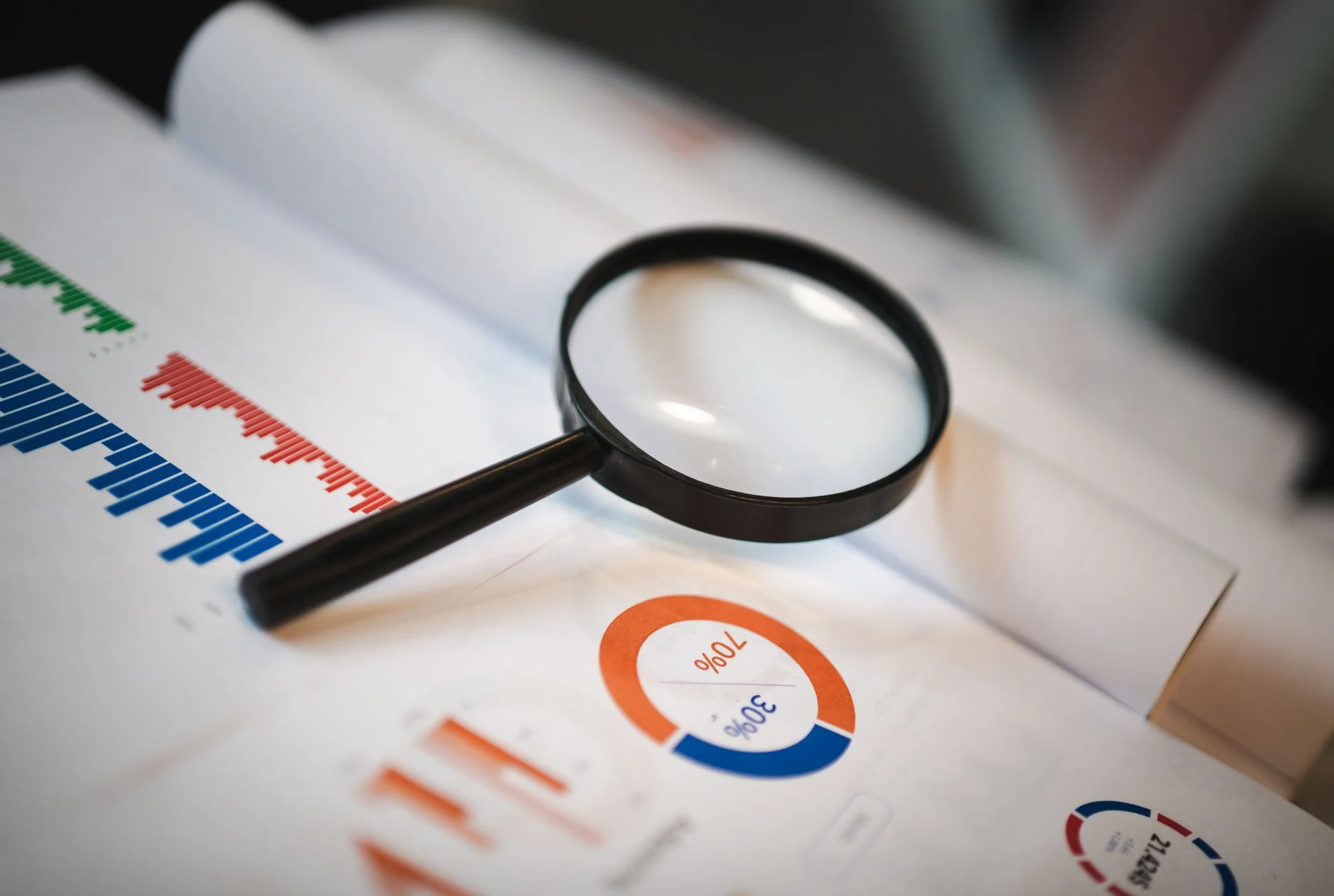 A magnifying glass held over a printed document, representing a technical SEO audit
